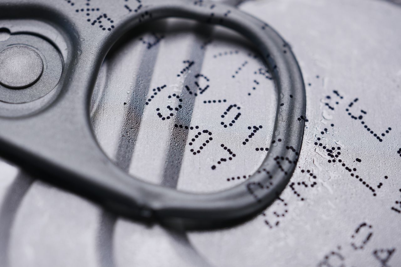 Detailed image of a drink can lid showing printed expiration date